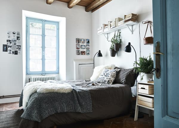 Un dormitori blau i blanc amb teixits acollidors.