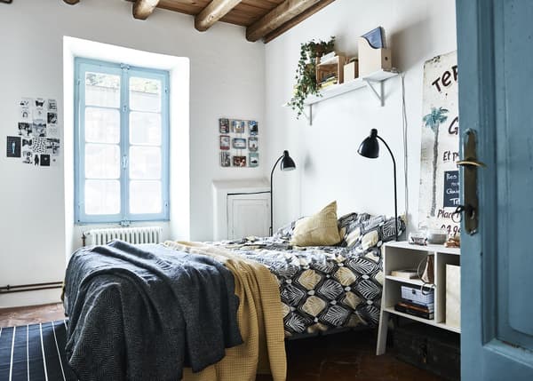 Un dormitori blau i blanc amb tocs grocs.