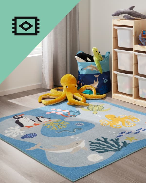 Un dormitorio con una alfombra infantil con motivo de mar.