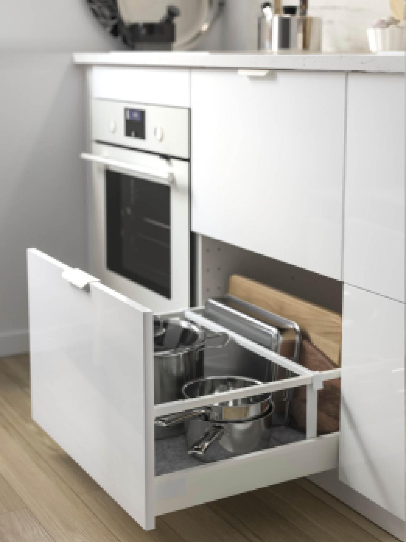 Un élément étroit coulissant est ouvert. À l’intérieur, des planches à découper sur une tablette inférieure et des bouteilles d’huile et condiments sur la tablette supérieure.