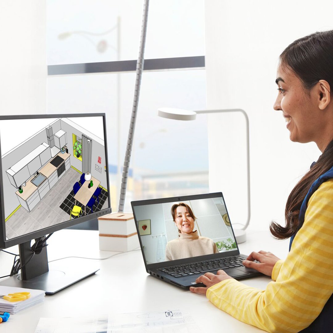 Un employé d'IKEA aide une dame à dessiner la cuisine de ses rêves.