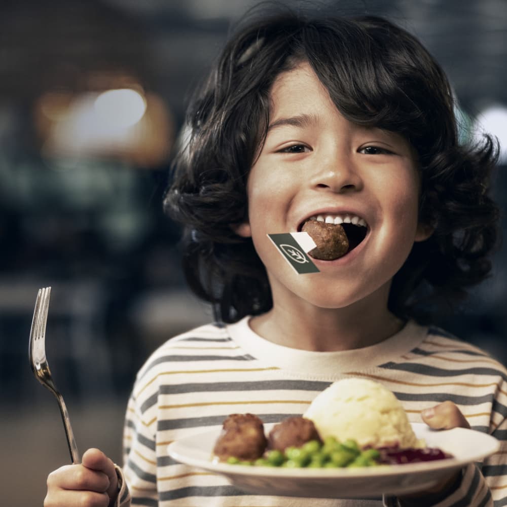 Un enfant qui mange des boulettes suédoises.