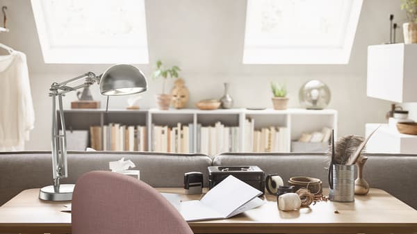Un espace de travail ouvert avec quatre bureaux, quatre chaises de bureau et quatre lampes de bureau.
