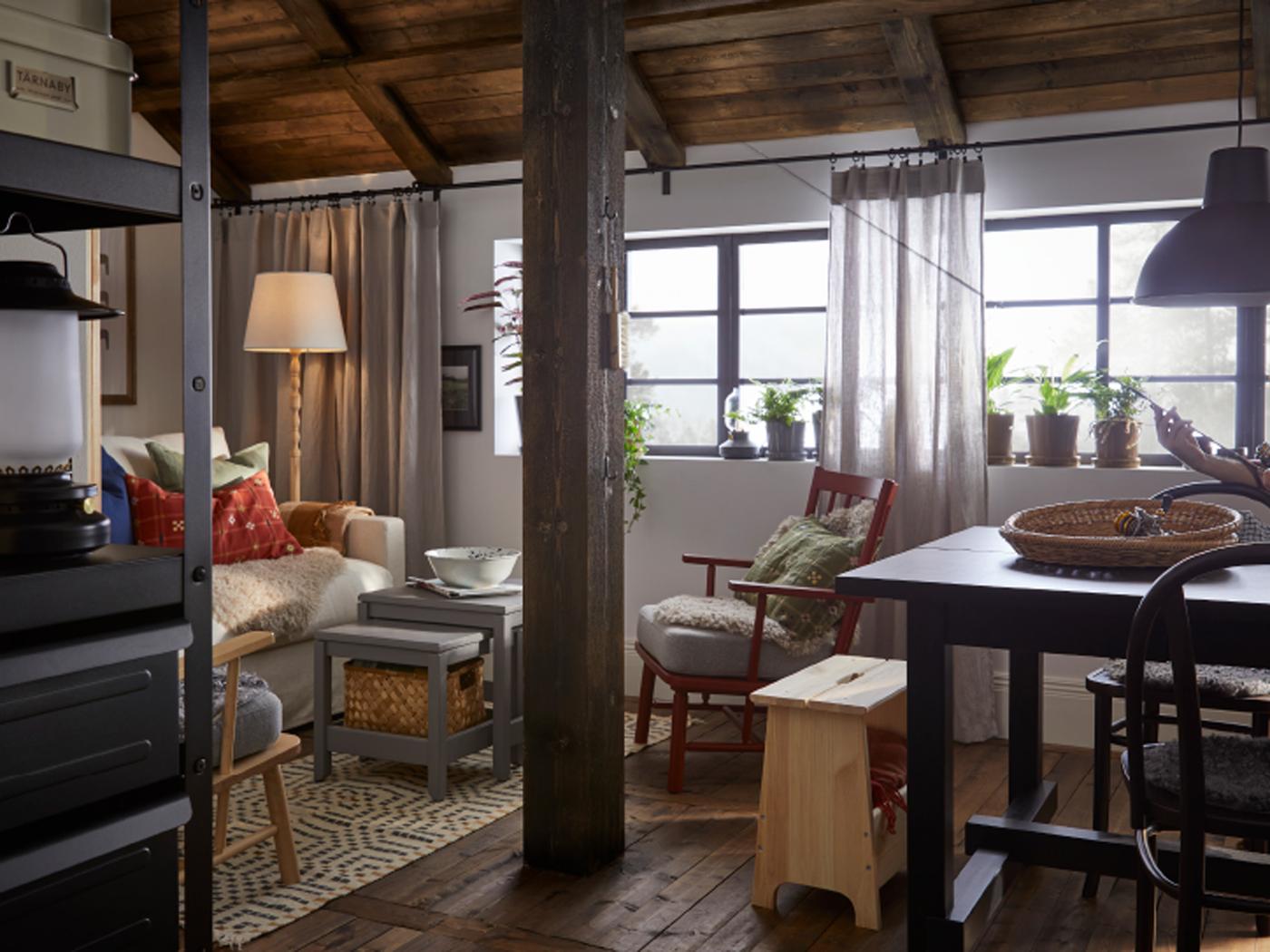 Un espace de vie lumineux dans un bâtiment de style traditionnel et rustique. Un fauteuil PERSBOL brun-rouge est placé sous la fenêtre.