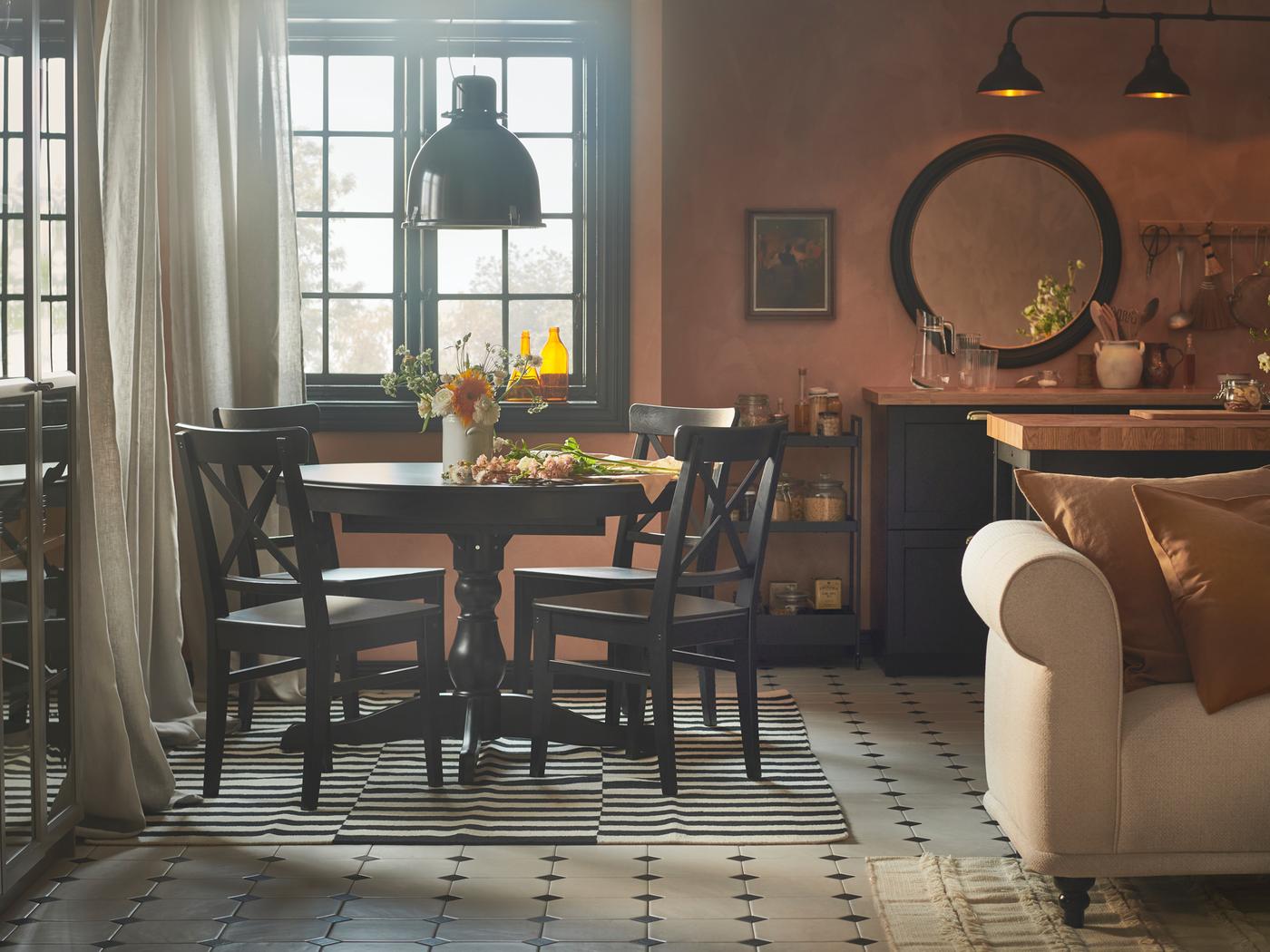 Un espace de vie rustique combinant salon, cuisine et salle à manger avec des murs couleur abricot, une table à rallonge INGATORP et quatre chaises INGOLF.