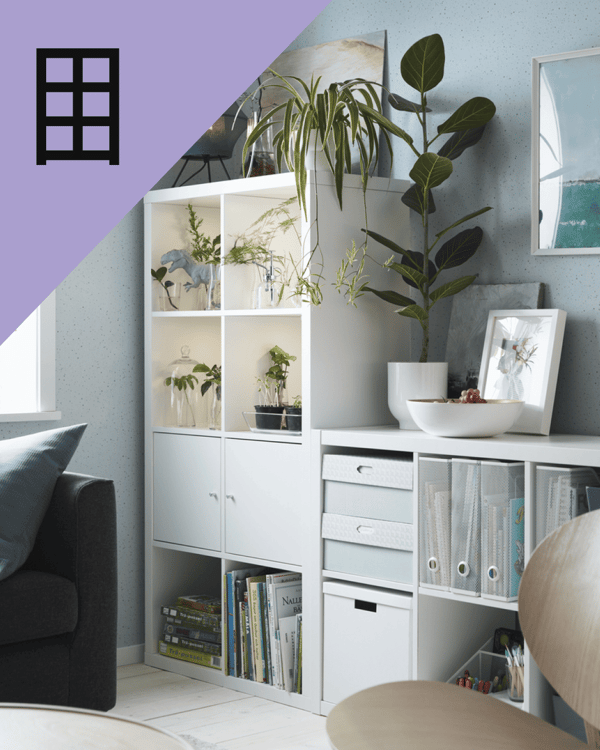 Un estante al costado de un mueble KALLAX con archivadores y decoraciones.