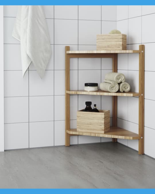 Un estante esquinero de baño con toallas y cajas organizadoras.