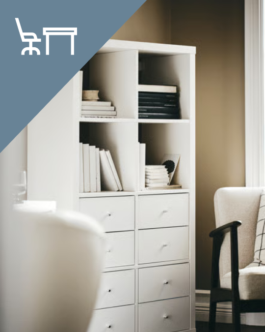 Un estante KALLAX blanco con cajones en su parte inferior y en las repisas libros-