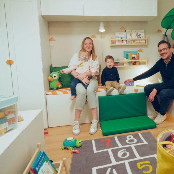 Un famille, deux parents, deux enfants, assis dans leur salle de jeu