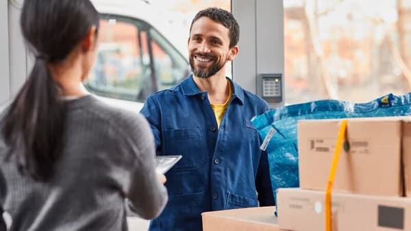 Un fattorino sta consegnando ad una donna i sui prodotti IKEA in consegna a casa o presso un punto di ritiro.