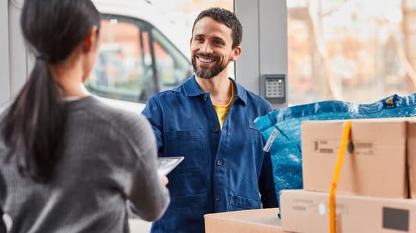 Un fattorino sta consegnando ad una donna i sui prodotti IKEA in consegna a casa o presso un punto di ritiro