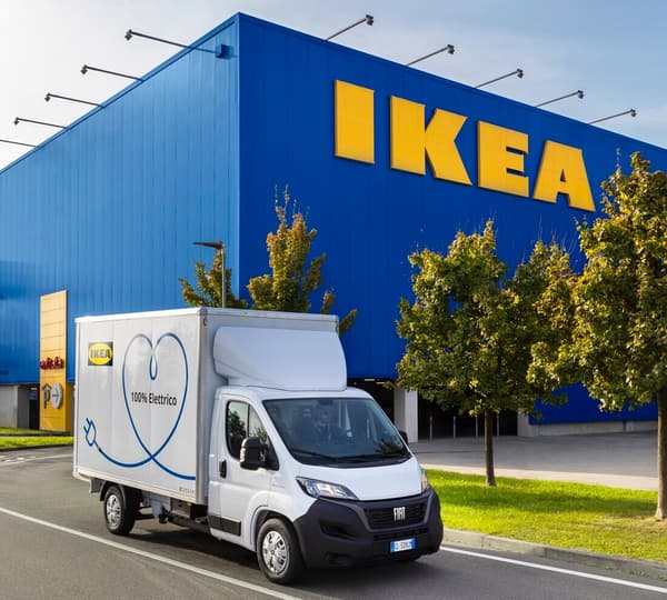 Un furgone bianco 100% elettrico parcheggiato accanto ad un negozio IKEA. 