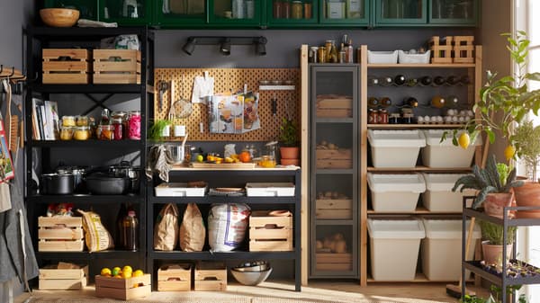 Un garde-manger avec un mur entier rempli d’étagères murales, de rangements et de boîtes pour ranger les produits alimentaires et les ustensiles de cuisine.