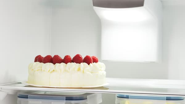 Un gâteau d'anniversaire dans un réfrigérateur ouvert