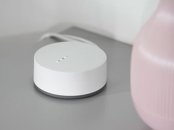 Un gateway TRÅDFRI è appoggiato su un comodino IKEA.