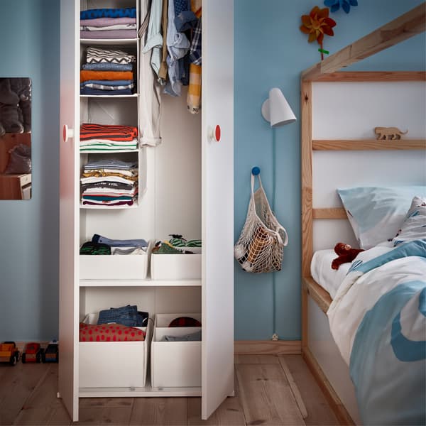 Un gran closet IKEA abierto con cosas para niños y adultos
