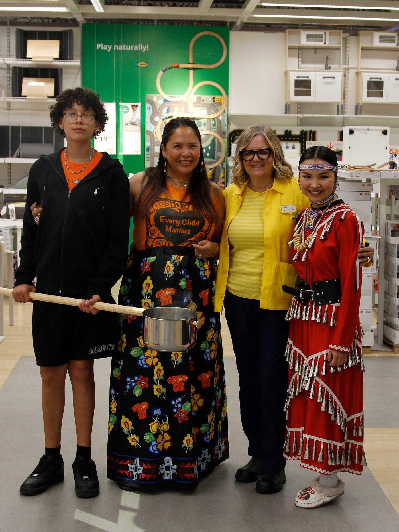 Un groupe de personnes est debout dans un magasin IKEA avec un pot de purification. 