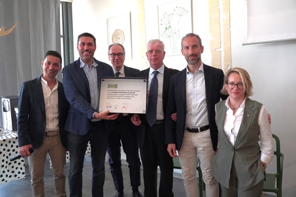 Un gruppo di persone che mostra una targa che certifica la partecipazione alla campagna EnergyPOP. 