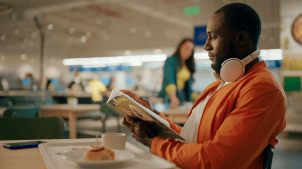 Un hombre leyendo un libro en el restaurant de IKEA.
