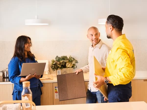Un hombre planificando junto a una pareja de colaboradores de IKEA.