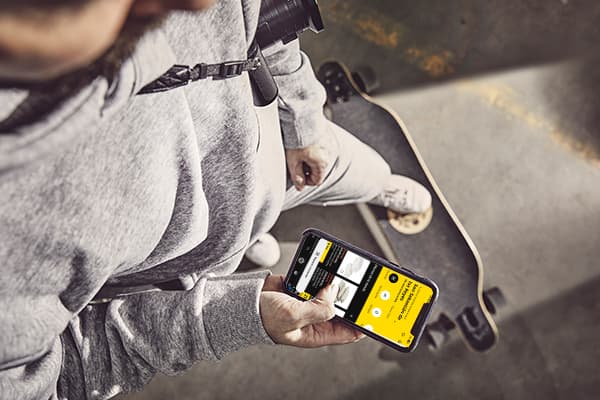 Un home vestit amb xandall gris busca un article a l'aplicació IKEA amb el mòbil.