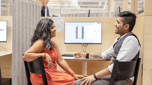 Un homme et une femme sourient tout en planifiant une cuisine à l’aide d’une collaboratrice IKEA.