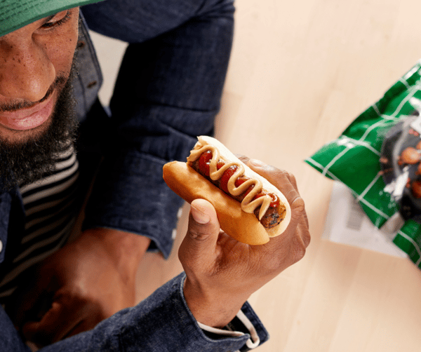 un homme mangeant un hot dog