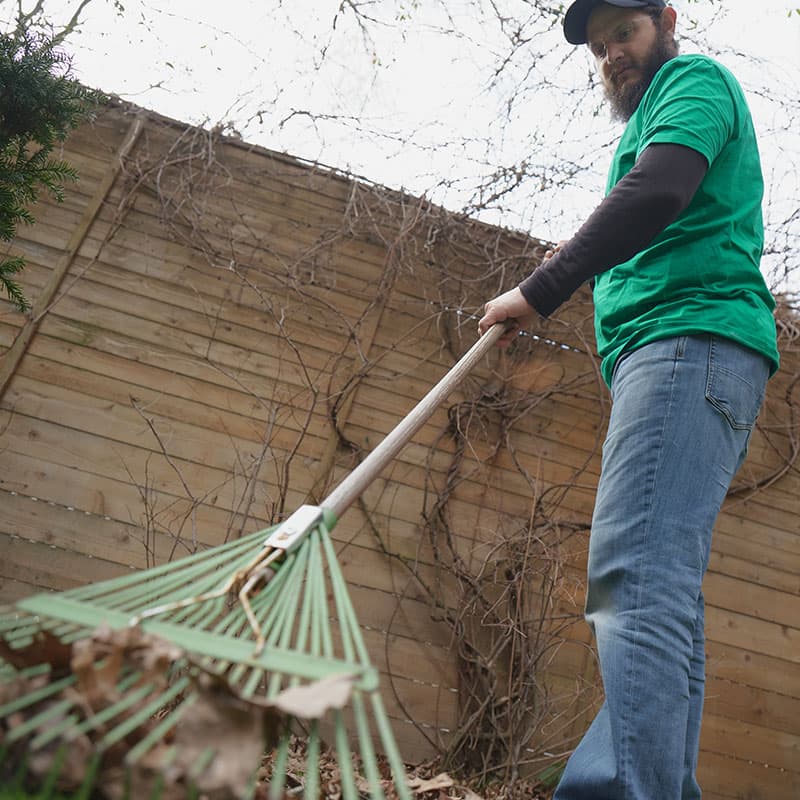 Un homme ratissant les feuilles