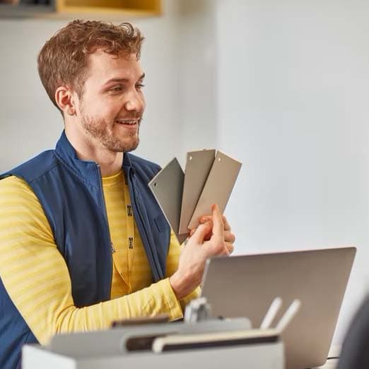 Un homme tient des échantillons de couleurs.