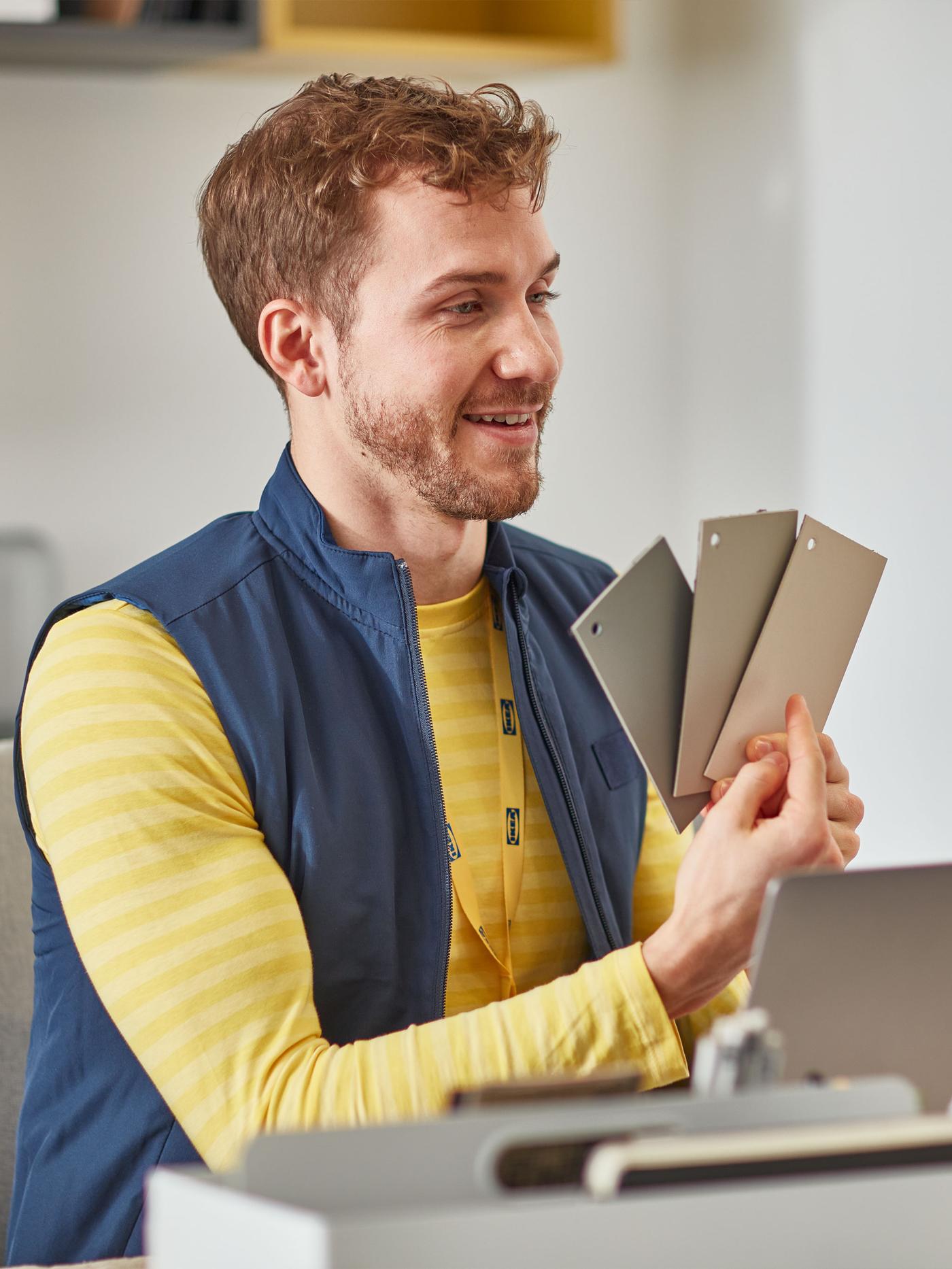 Un homme vêtu d’un uniforme IKEA tient des échantillons de couleurs