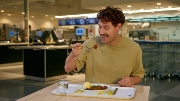 Un joven probando un plato de albóndigas IKEA en el restaurant de la tienda.