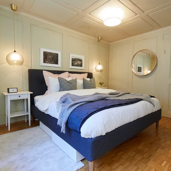 Un letto grigio con accanto dei comodini si trova in una camera da letto di un bed & breakfast