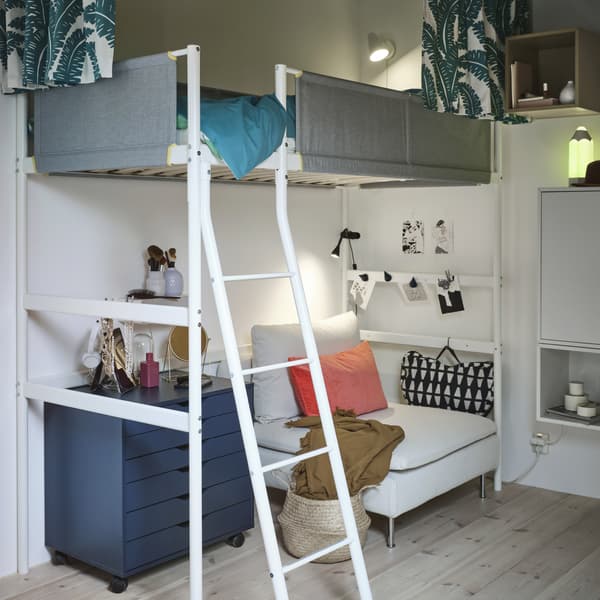 Un lit mezzanine blanc avec des garde-corps gris, et en dessous une section de canapé 1 place blanc, un bloc tiroir bleu et un support pour ordinateur portable.