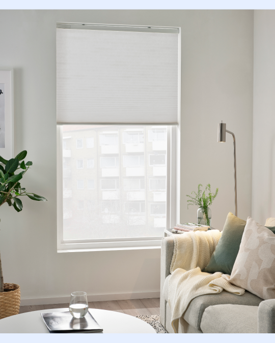 Un living con cortinas eléctricas roller color gris claro.