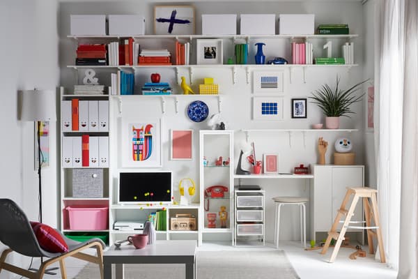 Un living con una pared completa con estantes y repisas dedicados al almacenamiento de libros, juguetes, artículos de colección y revistas.