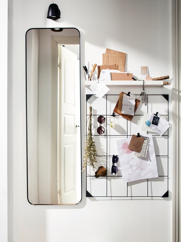 Un long miroir LINDBYN, un tableau d’affichage avec pinces SÖSDALA en fil d’acier noir et une tablette pour ranger des notes et des lunettes de soleil.