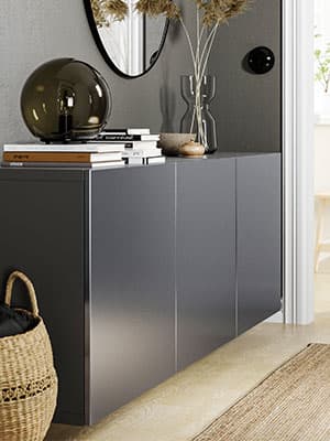 Un meuble de rangement RIKSVIKEN situé à l'entrée d'une maison et sur lequel y est osé une lampe.