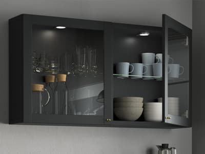 un meuble haut fixé au mur avec une porte ouverte. On y voit de la vaisselle et une lumière