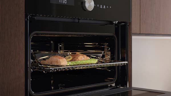 Un micro-onde ouvert avec un plat à l'intérieur de poissons et légumes