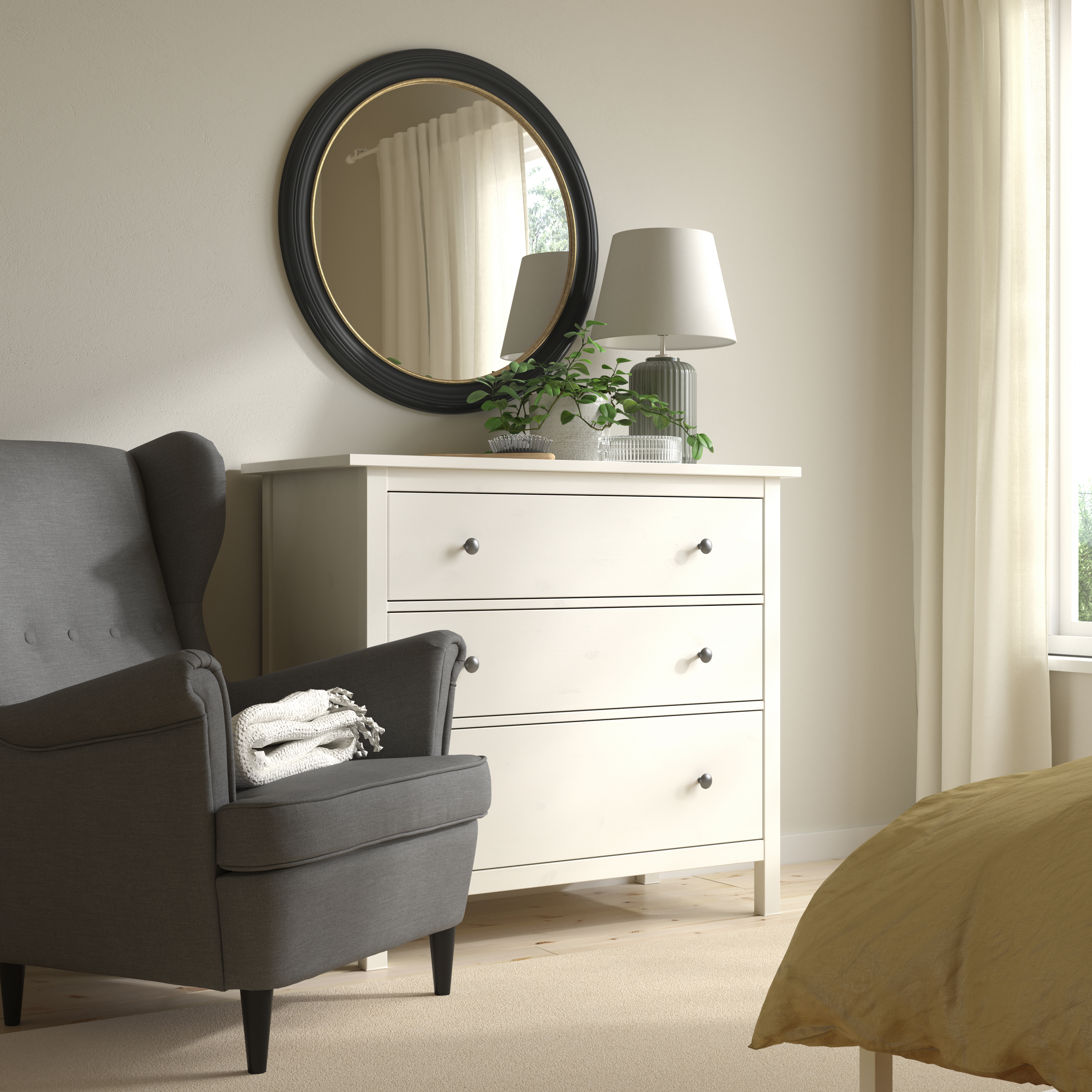 un miroir rond noir et une commode blanche