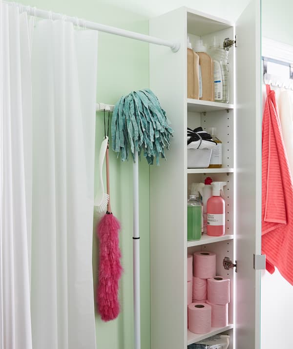 Un mobile aperto con gli accessori per il bagno e una tenda doccia appesa lungo la parete che crea un ambiente separato - IKEA