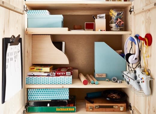 Un mobile IVAR usato per organizzare i giochi, con cestini per i joystick, ganci per le cuffie e portariviste per riporre giochi e accessori vari - IKEA