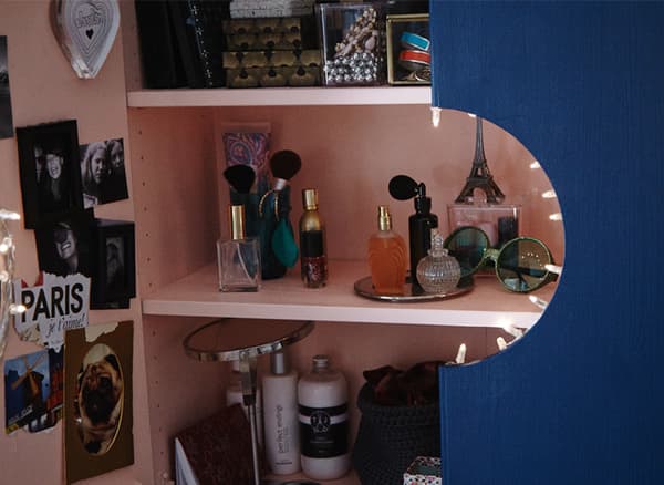 Un mobile IVAR verniciato di rosa all'interno e di blu all'esterno con un foro al centro tra le due ante che lascia intravedere il contenuto - IKEA