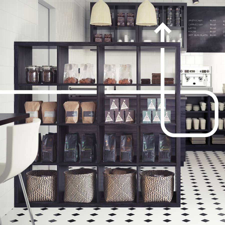 Un mobile KALLAX utilizzato come dispensa in una cucina con diverse ceste. 