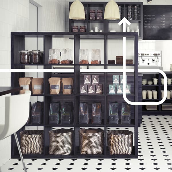 Un mobile KALLAX utilizzato come dispensa in una cucina con diverse ceste. 