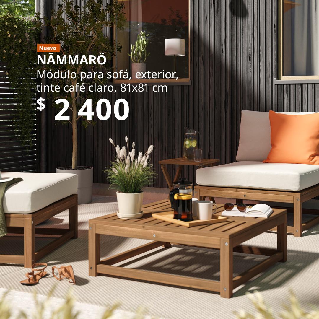 Un módulo para sofá NÄMMARÖ en tono café claro utilizado como mesa de centro, colocado en una terraza exterior junto a módulos para sofá y elementos decorativos.