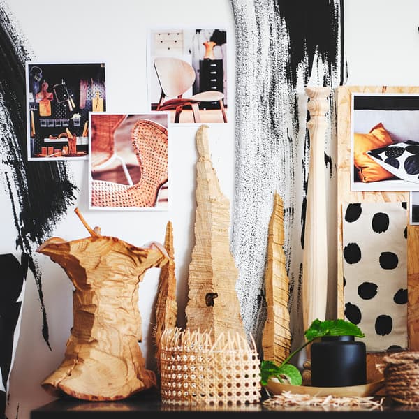Un moodboard composé d’éléments collés au mur, derrière des objets en matériaux naturels regroupés de manière créative.