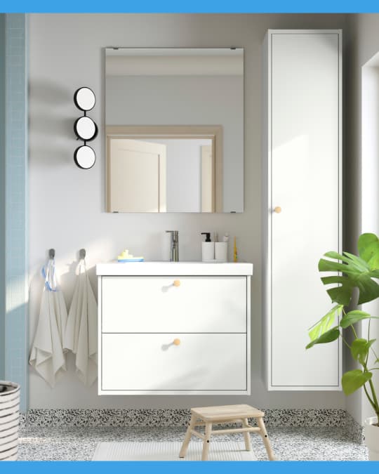 Un mueble para lavamanos blanco de dos cajones flotante y arriba un espejo de baño rectangular.