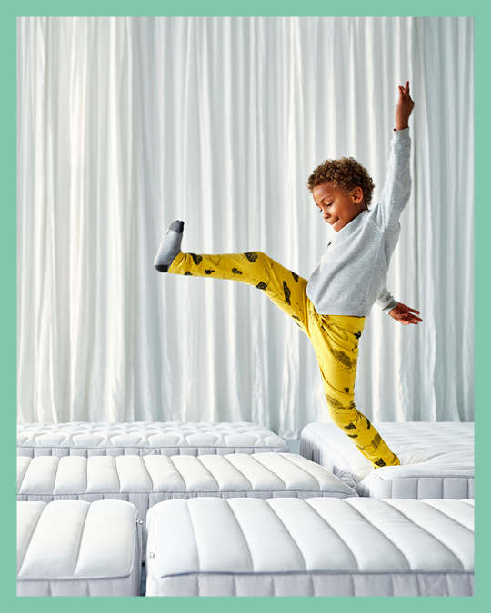 Un niño caminando sobre una fila de colchones IKEA.