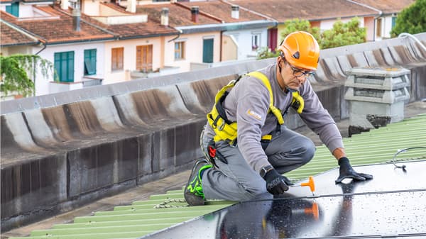 Un operaio lavora all'installazione di un pannello fotovoltaico. 